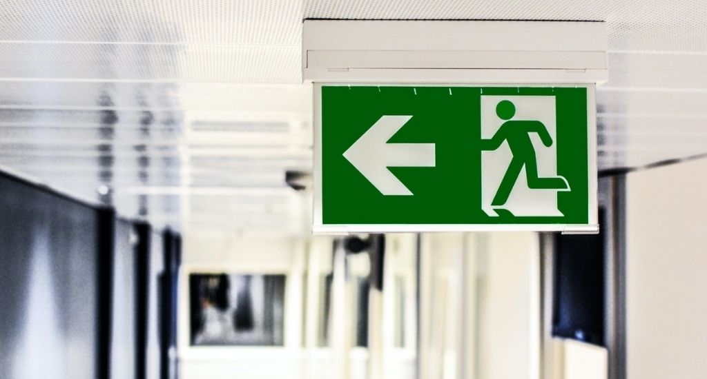 Green emergency evacuation sign pointing to exit