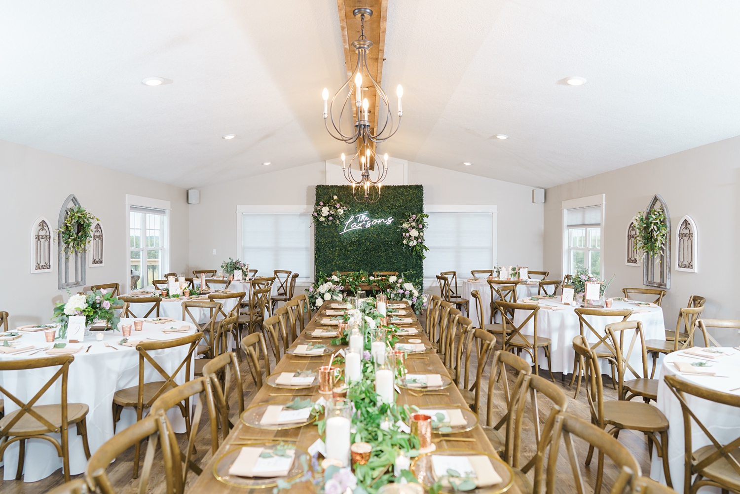 alta house wedding reception in newton iowa with greenery backdrop, farmhouse tables, and lavender and copper details