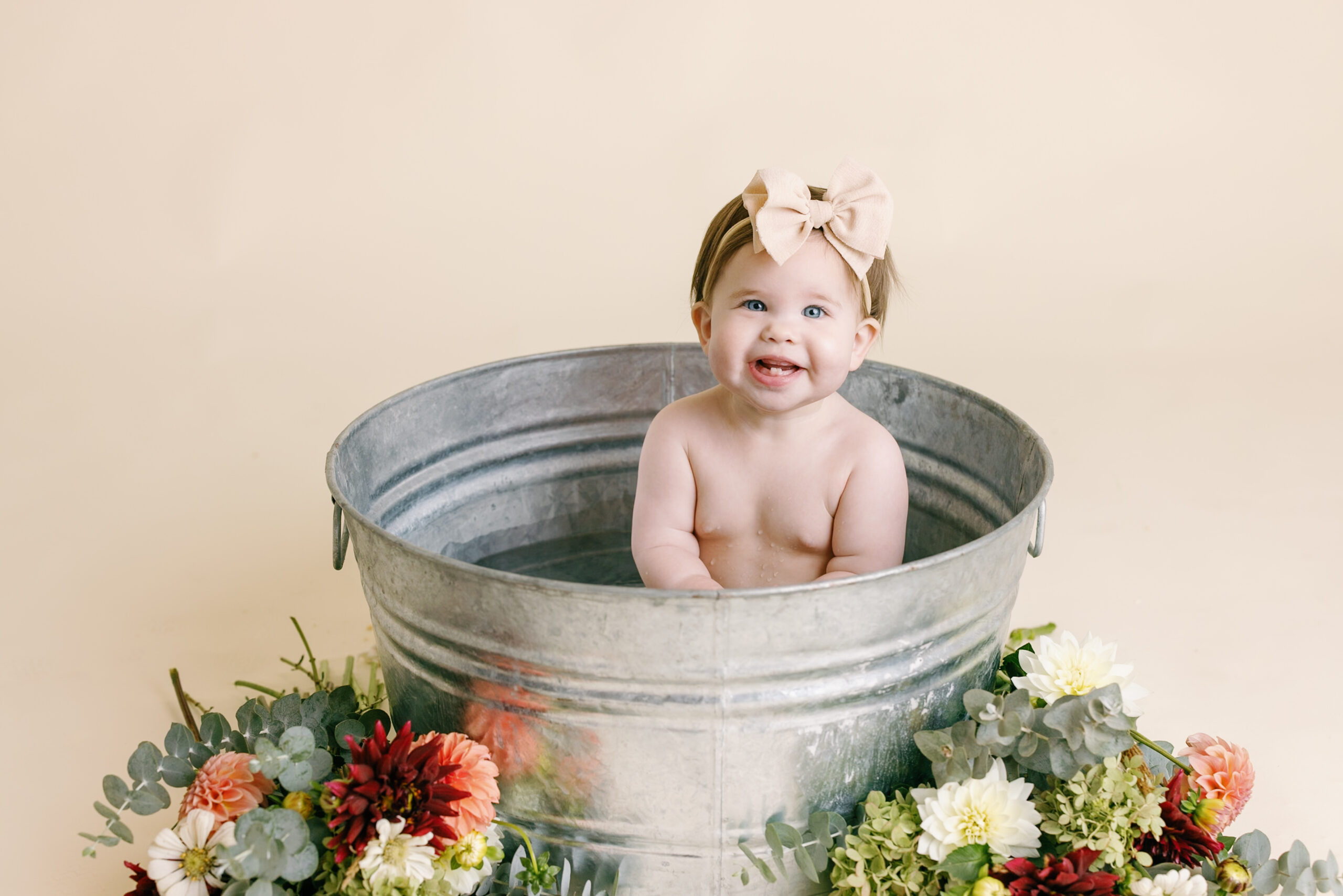 Photo of baby in a giant steel bucket with flowers