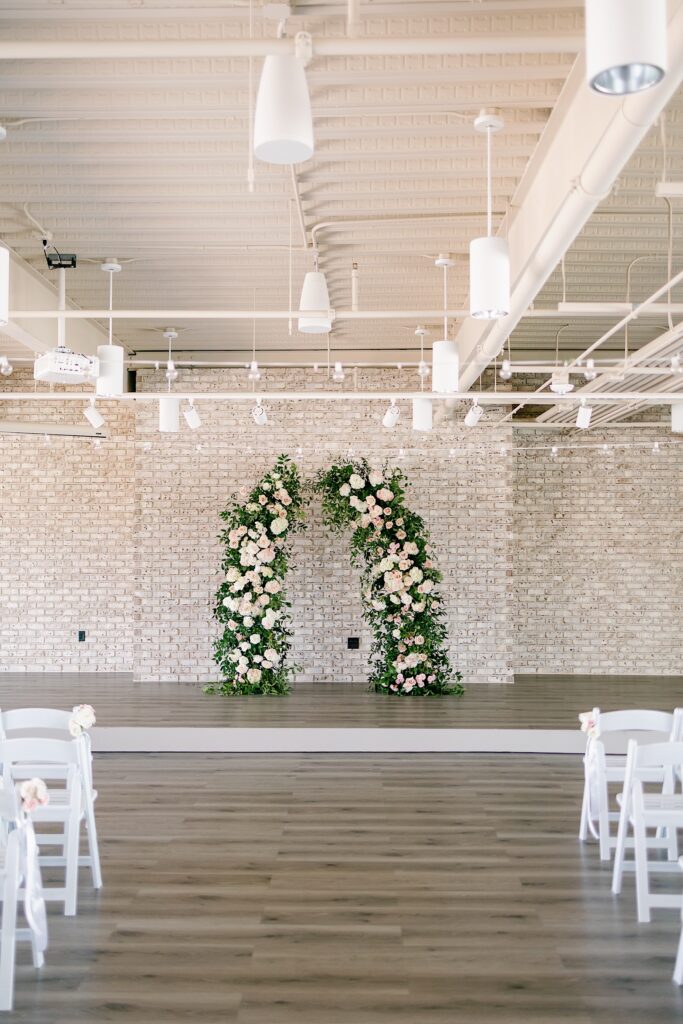 Toast wedding photos in Des Moines with floral arch