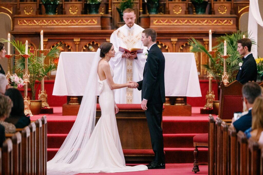Bride and groom exchanging vows during a Catholic ceremony at St. Mary’s Catholic Church in Iowa City.