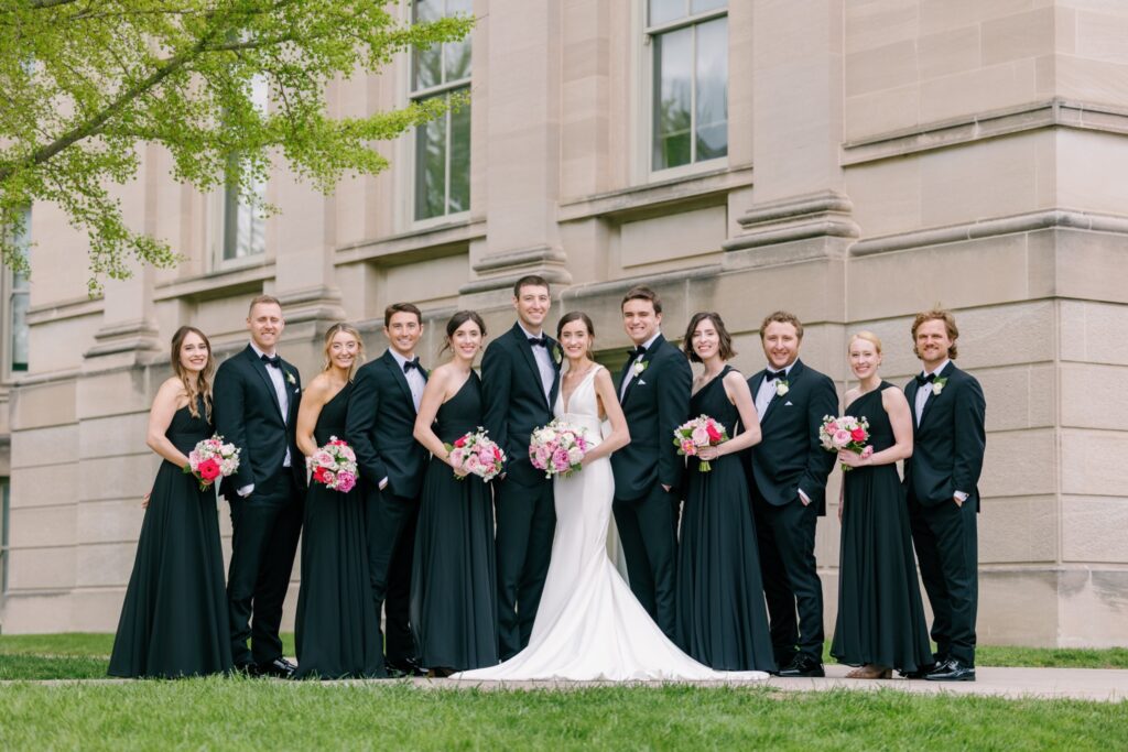 timeless Wedding photos of bridesmaids with black dresses at University of Iowa with long wedding veil and pink peony wedding bouquet