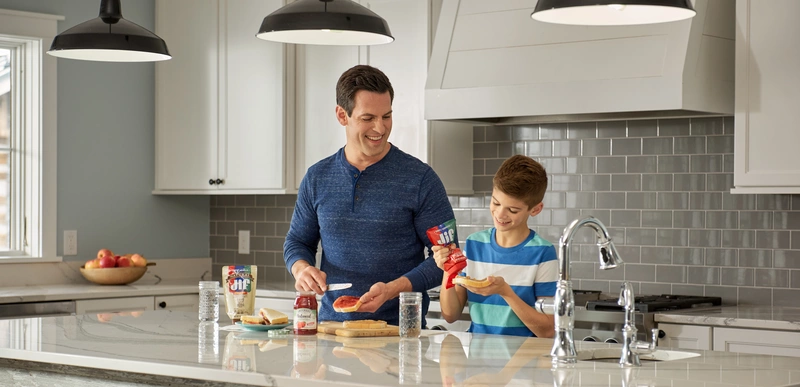 father and son making peanut butter and jelly sandwiches