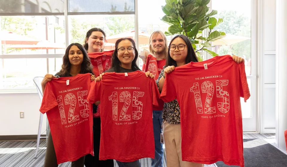 group of interns holding up smucker t shirts