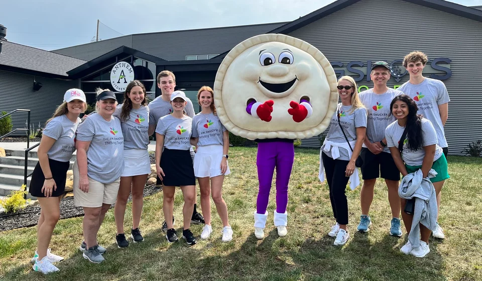 group of interns posing with uncrustables mascot