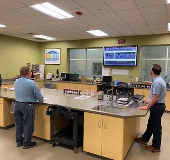 Workers reviewing monitor in shared room