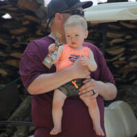 Kevin McKinnon with his youngest child at the 2018 Doyle Lawson & Quicksilver Bluegrass Festival - photo by Laura Tate Photography