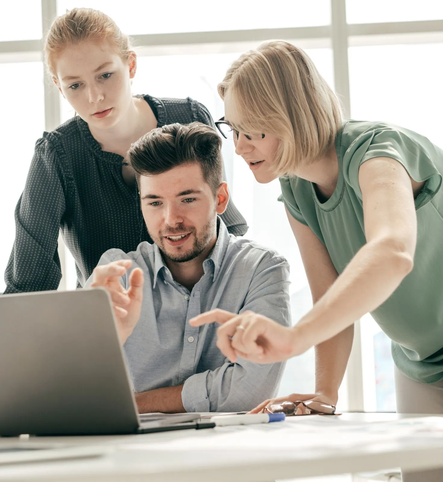 2-women-and-1-man-looking-at-laptop