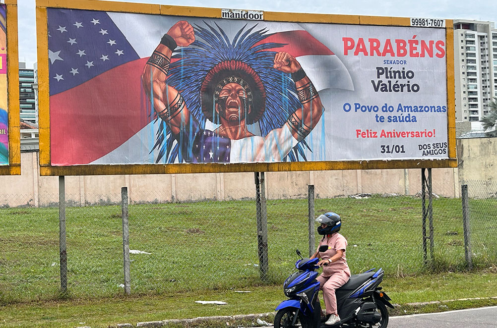 Outdoor que parabeniza Plínio Valério traz indígena com cocar norte-americano