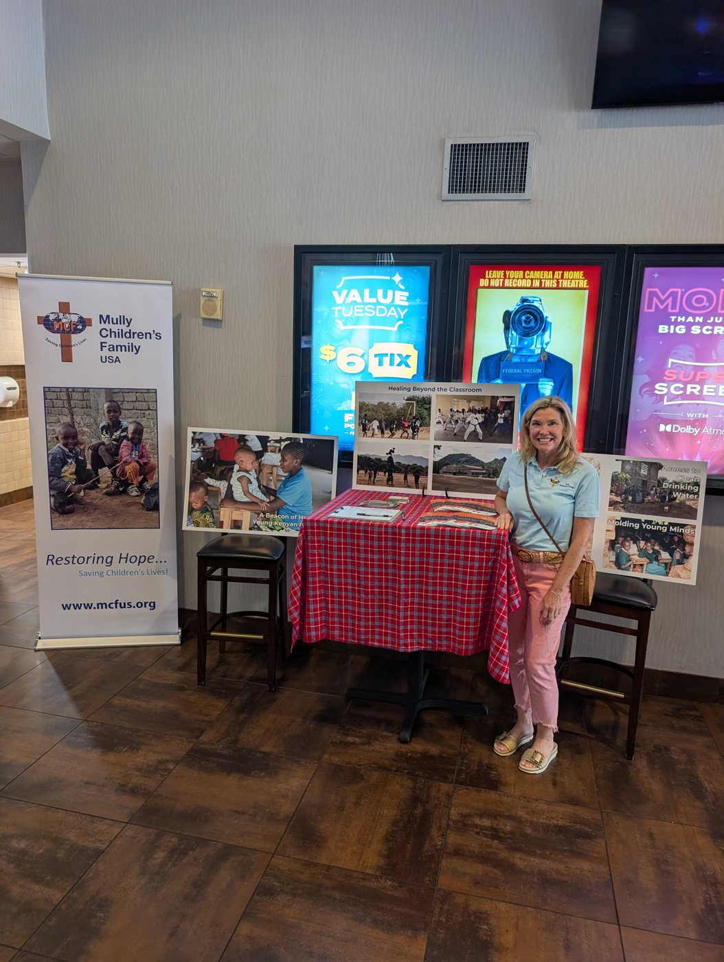 MCF team member at a lobby table with MULLY materials before a screening
