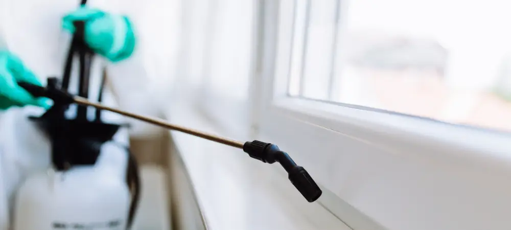 pest control specialist sprays window sill for pests