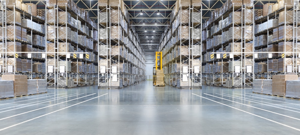 Huge distribution warehouse with high shelves and loaders.