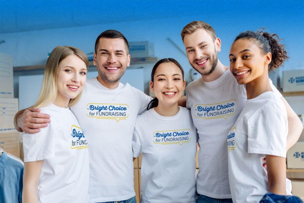 Group of five volunteers, men and women, wearing shirts that say "The Bright Choice for Fundraising". There are boxes of pastries in the background.