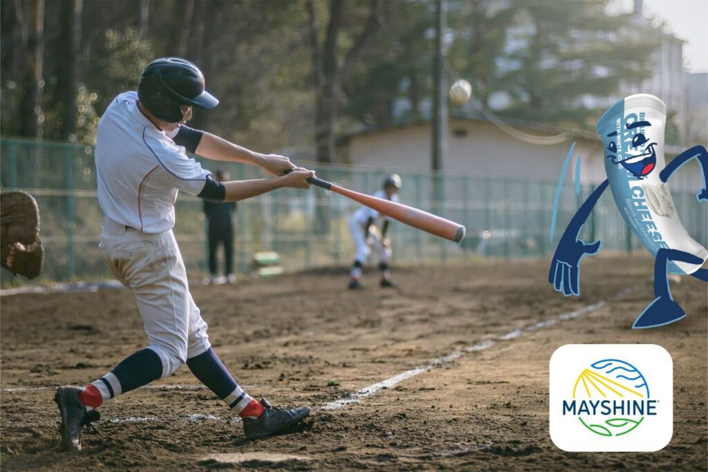 A game of baseball - the batter is swinging at a pitch, and the pitcher is a Cream Cheese Pastry Pal.