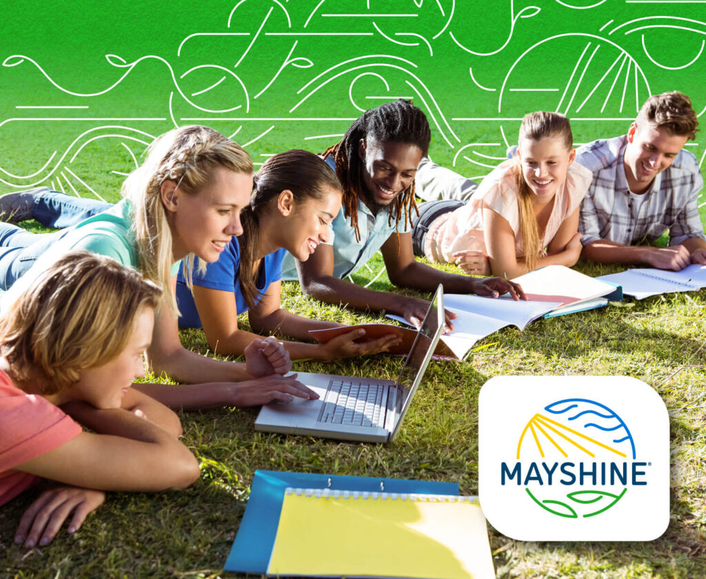 Group of high school students on the lawn looking over school and fundraising materials.