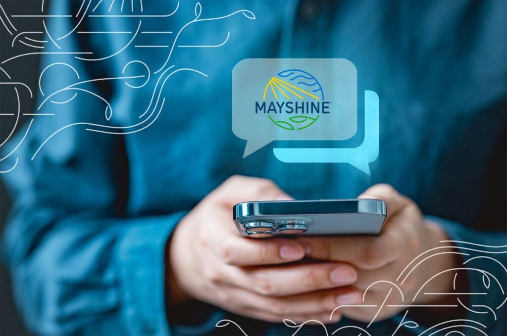 Mobile fundraising tool - texting - a person using a cell phone with text bubbles popping out of the phone. One of the bubbles shows a Mayshine logo.