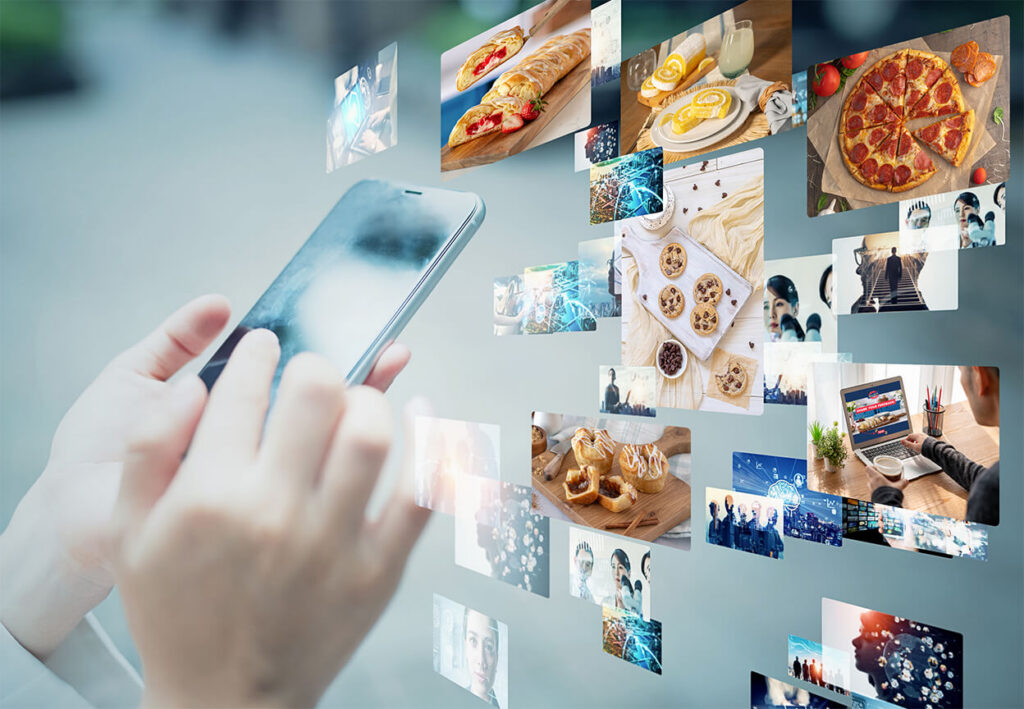 A person holding a phone - a bunch of photos are shown around the phone of fundraising products and promotional images to illustrate the use of mobile & social media fundraising tools.
