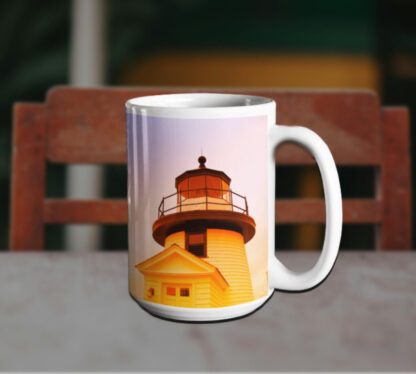 White nautical coffee mug with an image of a lighthouse at sunset, featuring warm orange and yellow hues.