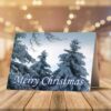 A Christmas card on a wooden table features snowy pine trees and "Merry Christmas" text. Nearby are candy canes and pine sprigs, creating a festive scene.