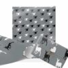 Monochrome Christmas wrapping paper features a pattern of alternating black and white deer on a gray background. A wrapped gift is tied with a thin twine and a heart tag.