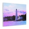 A vibrant canvas print depicts a white lighthouse by the sea, set against a pastel pink and purple sunset. Nearby houses are surrounded by lush greenery. A modern couch with a white cushion sits below, and a green plant peeks from the side, creating a calm and serene atmosphere.