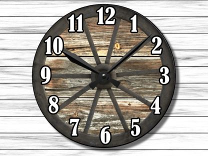 Rustic wall clock with a wagon wheel design sits against a white wooden panel background. Large black numbers and black hands stand out clearly.