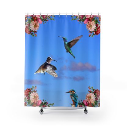 A vibrant blue shower curtain features two hovering hummingbirds and a perched kingfisher. Colorful flowers adorn the top corners, evoking a lively, tropical feel.