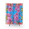 Shower curtain with vibrant pink and yellow flowers on a bright blue background. The floral pattern creates a cheerful, lively ambiance.