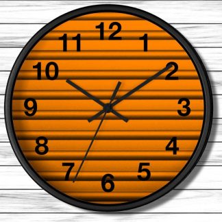 A round wall clock with a black frame features an orange, textured background. Black numbers and hands indicate the time, showing approximately 10:10.