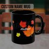 Black mug featuring red and yellow autumn leaves with the personalized custom name "Andrew" in white script. The design conveys a cozy, fall-inspired theme.