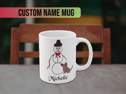 A white mug featuring a whimsical drawing of a snowman with a bow tie and hat, standing by a small brown dog. The personalized custom name "Michelle" is in black script below.