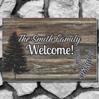 Welcome mat in a rustic wooden panel style on a gray stone step reads "The Smith Family Welcome!" against a stone background. Features a pine tree silhouette and lavender sprigs, conveying warmth.