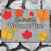 Welcome mat on a stone step reads "The Smith's Welcome You!" surrounded by vibrant red, orange, and yellow autumn leaves.