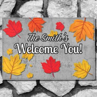 Welcome mat on a stone step reads "The Smith's Welcome You!" surrounded by vibrant red, orange, and yellow autumn leaves.