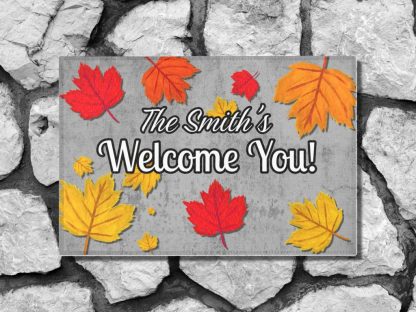 Welcome mat on a stone step reads "The Smith's Welcome You!" surrounded by vibrant red, orange, and yellow autumn leaves.