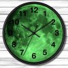 A round wall clock features a glowing green full moon design, black numbers, and hands, set against a white wooden panel background.