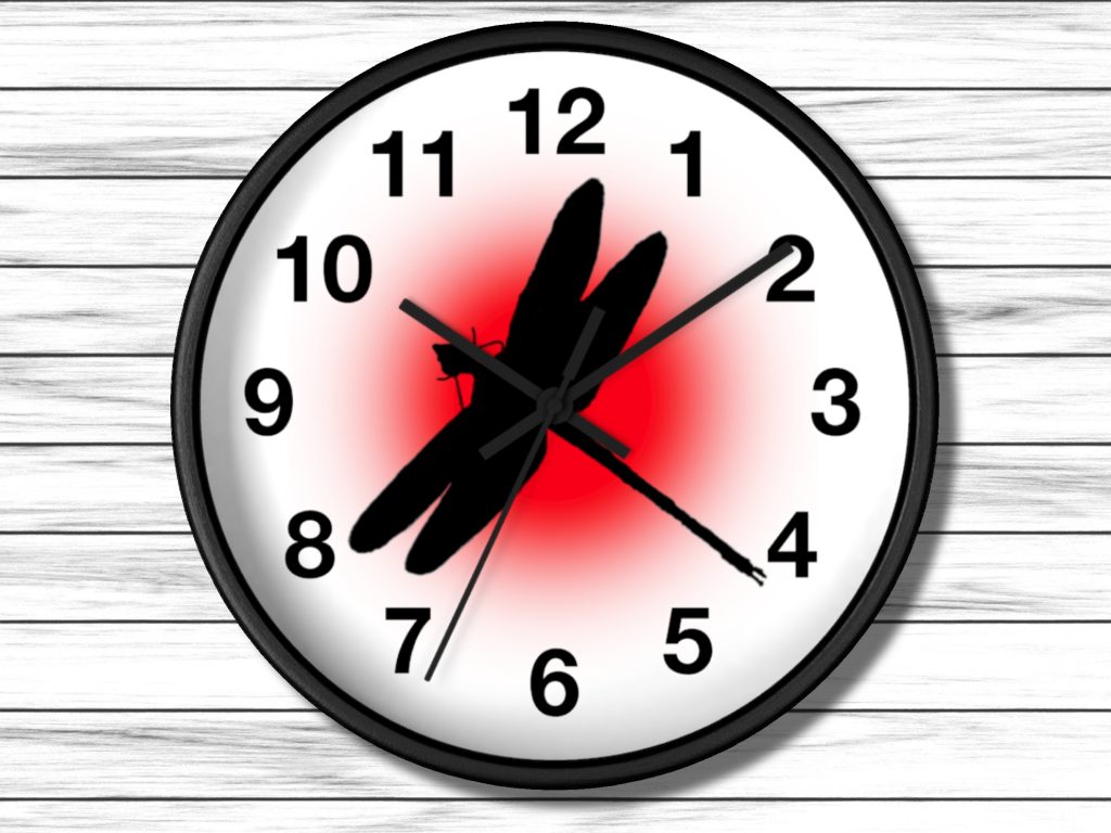 A wall clock with bold black numbers on a white face. The center features a black dragonfly silhouette against a bright red circle, creating contrast.