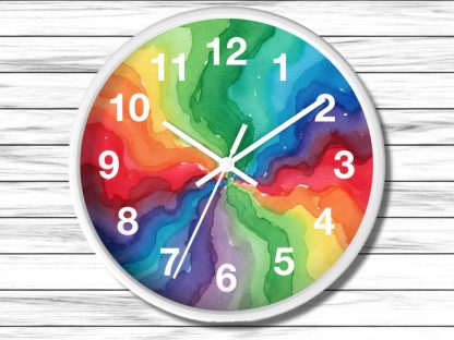 Round wall clock with a white frame, featuring vibrant watercolor swirls in rainbow colors. White numerals and clock hands stand out against the colorful background, creating a dynamic and cheerful visual. The clock is set against a white wooden surface.