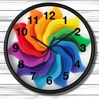 A vibrant clock with black numbers and hands features a swirling rainbow design in the center, set against a white wooden background.