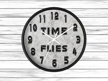 Round wall clock against a white wooden background. The clock face reads "TIME FLIES" between 10 and 2 o'clock, with bold black numbers.