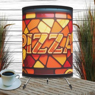 Stained glass lamp with "Pizza" text in bold letters, set on a wooden surface. Background includes tall grasses, creating a cozy ambiance.