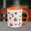 Orange-accented mug with autumn-themed designs, featuring pumpkins, apples, leaves, and coffee cups. Steam rises, suggesting a warm drink inside. Cozy vibe.
