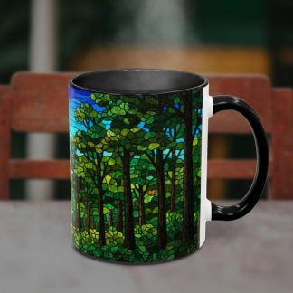 A steaming black mug sits on a table, featuring a vibrant stained-glass forest design with lush green trees and a blue sky, set against a blurred chair.