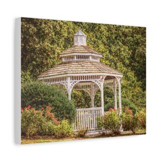 A cozy living room features a canvas wall art of a white gazebo surrounded by lush green foliage and pink flowers, exuding a serene and peaceful ambiance.