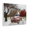 A vintage red truck is parked on a snowy path between trees, with a backdrop of a brick building. Snow gently falls, creating a serene winter scene. Canvas wall art.