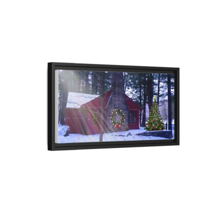 A framed canvas art on a wall shows a cozy cabin in winter, surrounded by snowy woods. A decorated Christmas tree and wreath add a festive touch.
