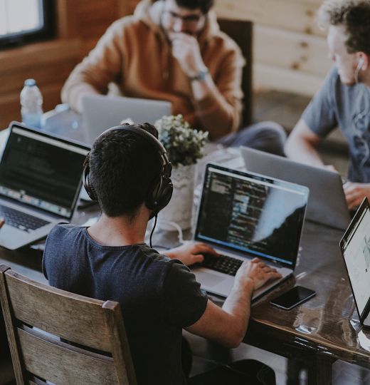 Multiple web developers working at a table.