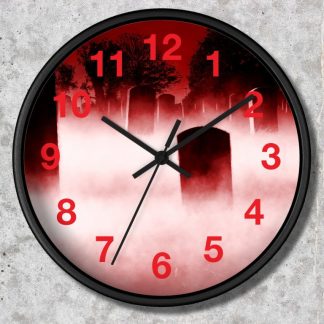 A wall clock displays a spooky cemetery scene in red and black tones. Red numbers and hands contrast against mist-covered tombstones and shadowy trees. Eerie ambiance.