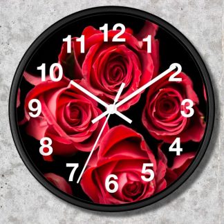 A round wall clock featuring vibrant red roses on a black background. White hour numbers and hands contrast against the vivid floral design, creating an elegant, romantic tone.