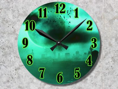 A round clock with black hands over a green, eerie cemetery scene. Bright green numbers and a moon with flying bats create a spooky atmosphere.